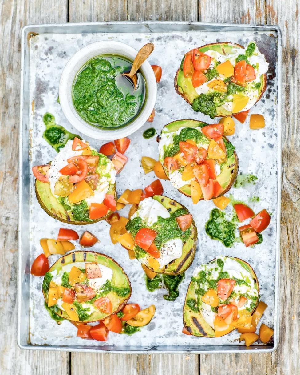 Grillade avokados med burrata, cocktailtomater och pesto